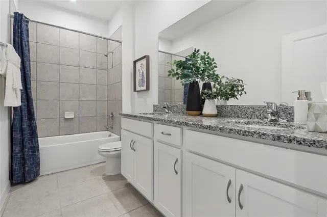 a bathroom with a granite countertop sink a toilet and shower