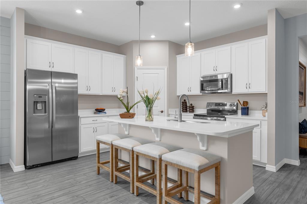 933 Pearlwood Loop Bartow, FL 33830 - Photo 6 of 39 a kitchen with kitchen island granite countertop a center island a sink stainless steel appliances and cabinets
