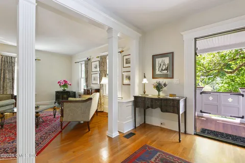 a living room with furniture floor to ceiling window and wooden floor