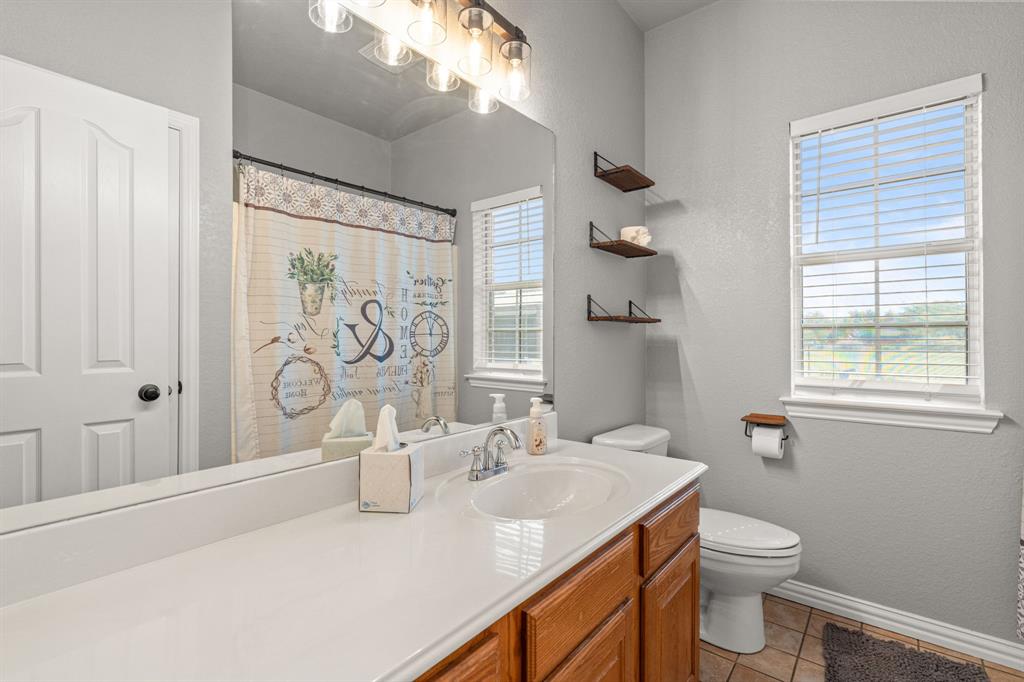 6501 Indian Trail Sanger, TX 76266 - Photo 14 of 39 Full bath featuring vanity, a shower with shower curtain, a textured wall, and light tile patterned floors