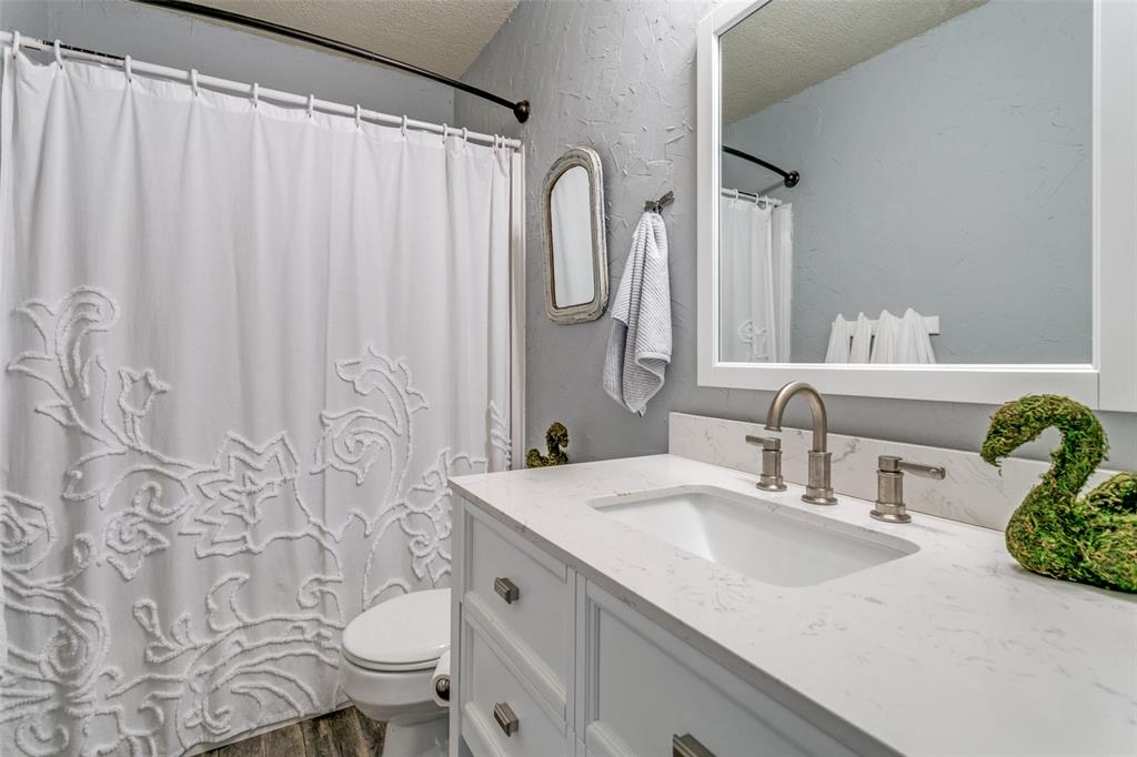 2133 Rim Rock Drive Keller, TX 76248 - Photo 30 of 37 Bathroom with a textured wall, vanity, a textured ceiling, and dark wood finished floors