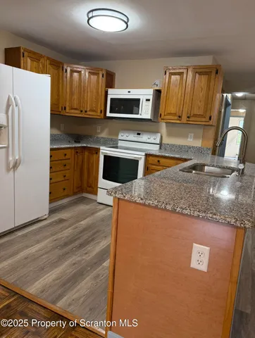 a kitchen with granite countertop a refrigerator stove and microwave