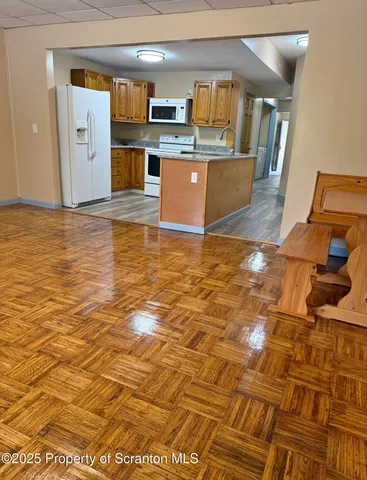 a view of a living room with kitchen countertops and wooden floor