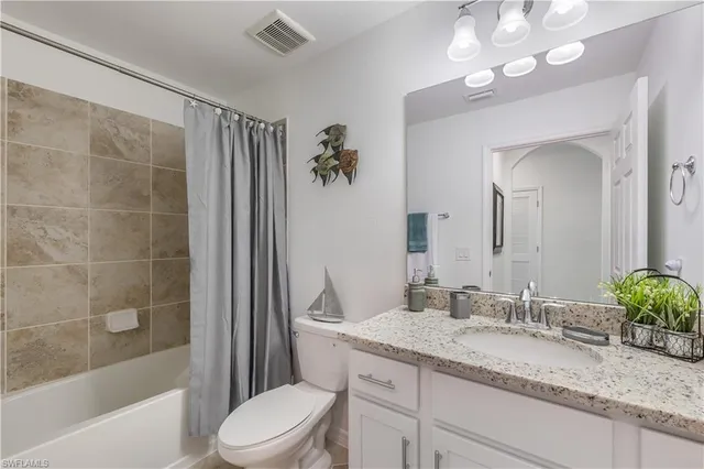 a bathroom with a granite countertop sink a toilet and a bathtub