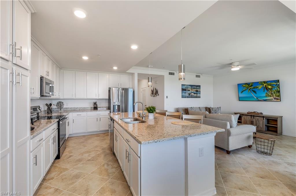 43020 Greenway Boulevard, Unit 333 Babcock Ranch, FL 33982 - Photo 6 of 11 a large white kitchen with stainless steel appliances lots of white cabinets