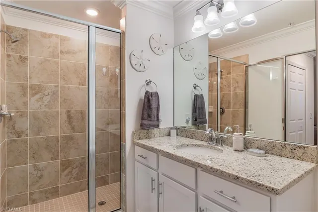 a bathroom with a granite countertop sink a mirror and shower