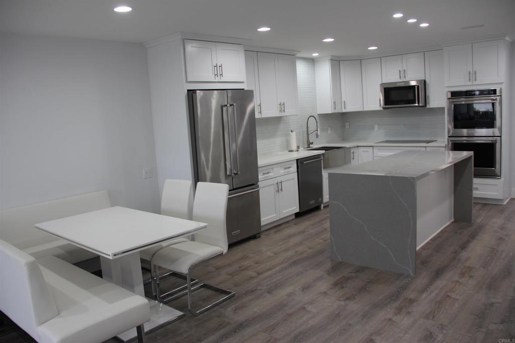 a kitchen with kitchen island stainless steel appliances a refrigerator and a stove top oven