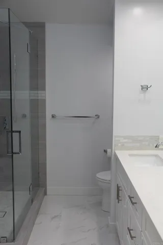 a bathroom with a granite countertop sink toilet and shower