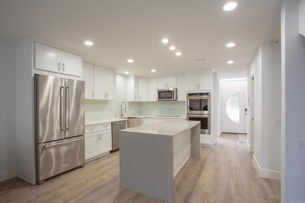 922 Sealane Drive, Unit B Encinitas, CA 92024 - Photo 4 of 30 a kitchen with white cabinets and stainless steel appliances