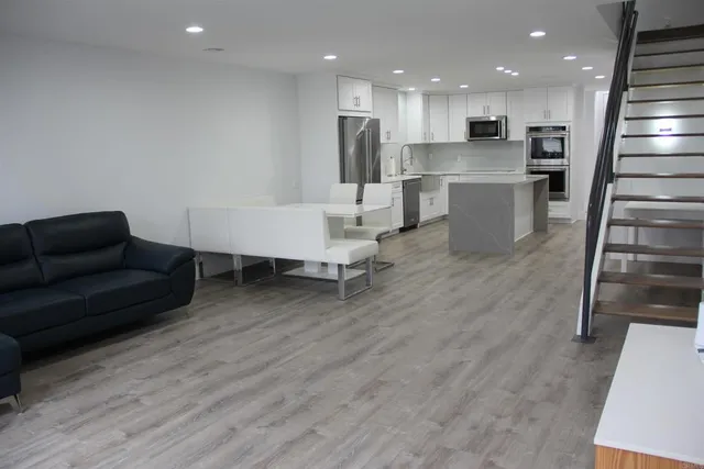 a living room with furniture and kitchen view