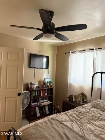 a bedroom with a bed and dresser with mirror