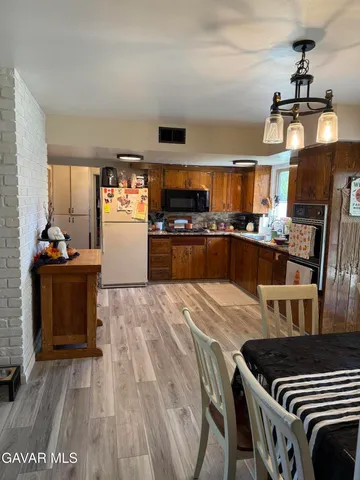 a kitchen with granite countertop a stove a sink and a refrigerator