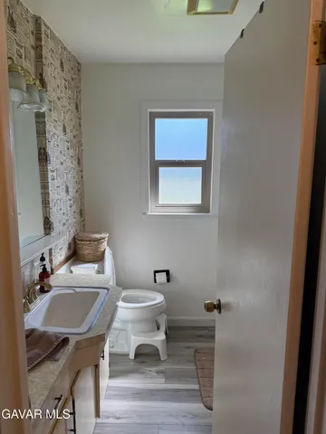a bathroom with a sink a toilet and a mirror