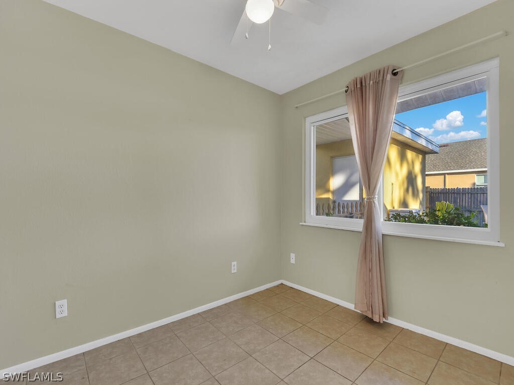 18426 Geranium Road Fort Myers, FL 33967 - Photo 20 of 25 an empty room with a window and chandelier