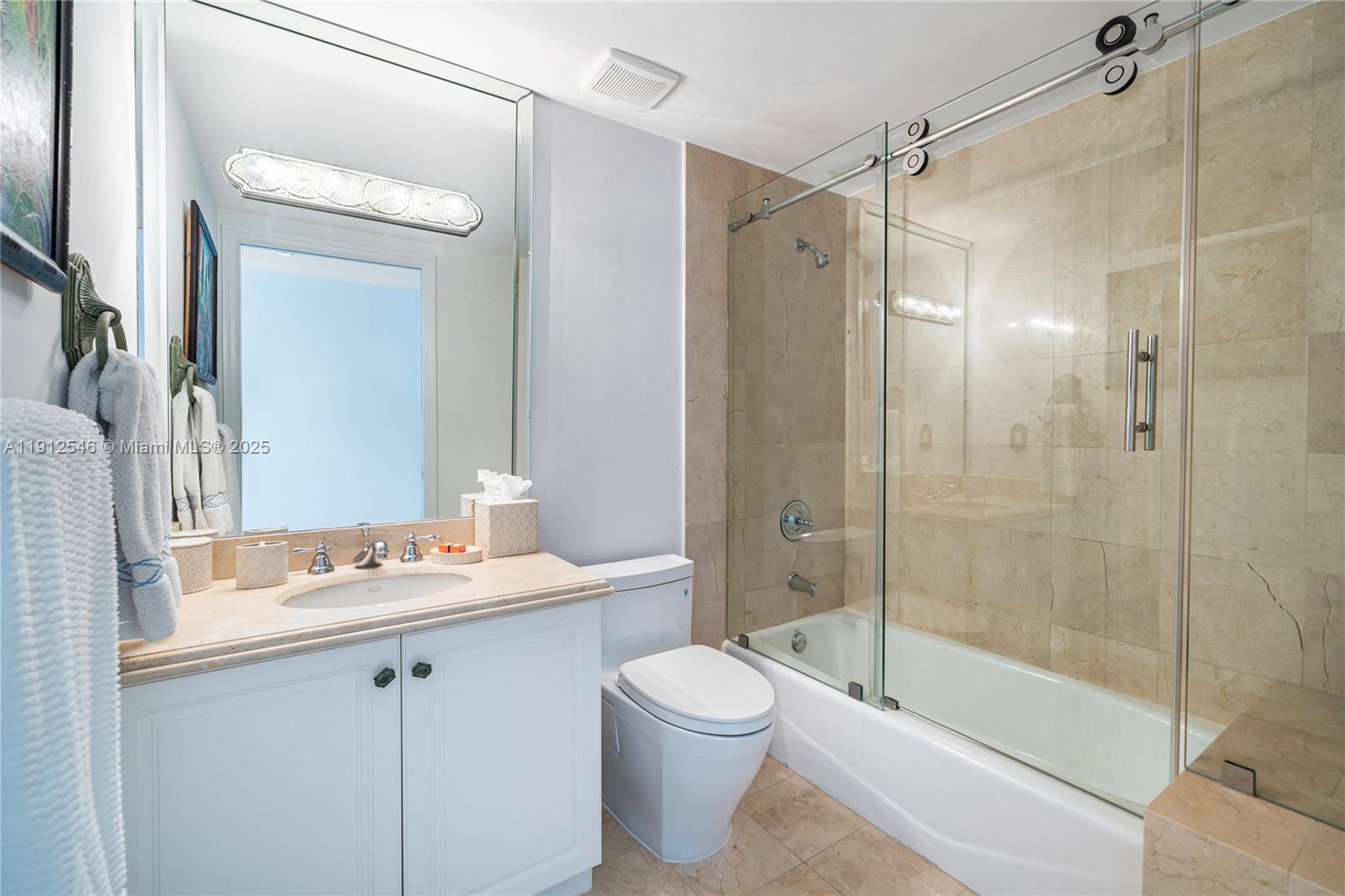 9559 Collins Avenue, Unit S7A Surfside, FL 33154 - Photo 26 of 43 a bathroom with a bathtub shower sink vanity and toilet