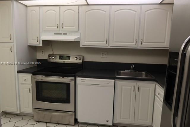 a kitchen with stainless steel appliances granite countertop white cabinets and a stove