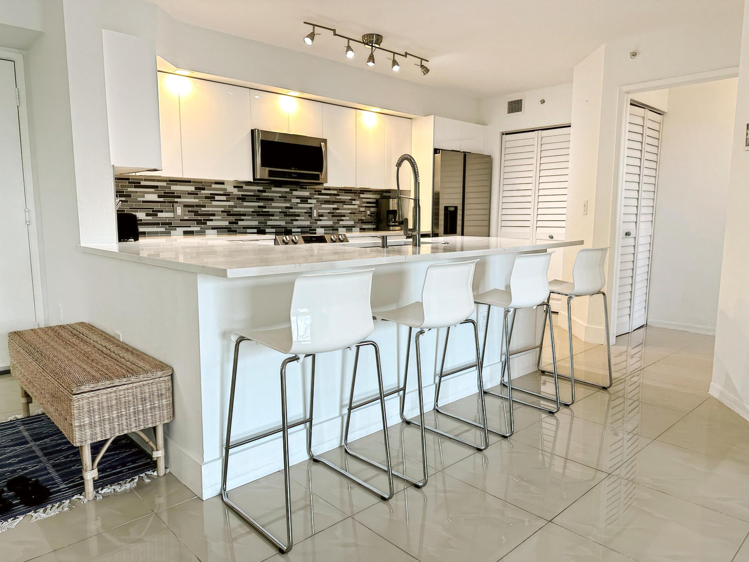 a kitchen with stainless steel appliances kitchen island granite countertop a stove a sink and a microwave