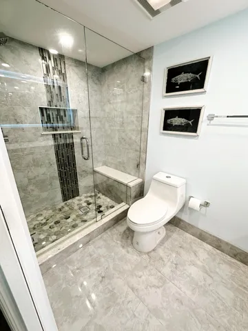 a bathroom with a toilet a sink and shower