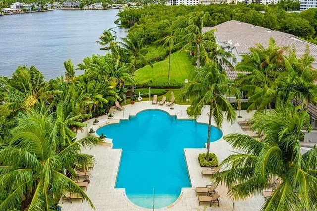 a view of a swimming pool with a yard and a bench