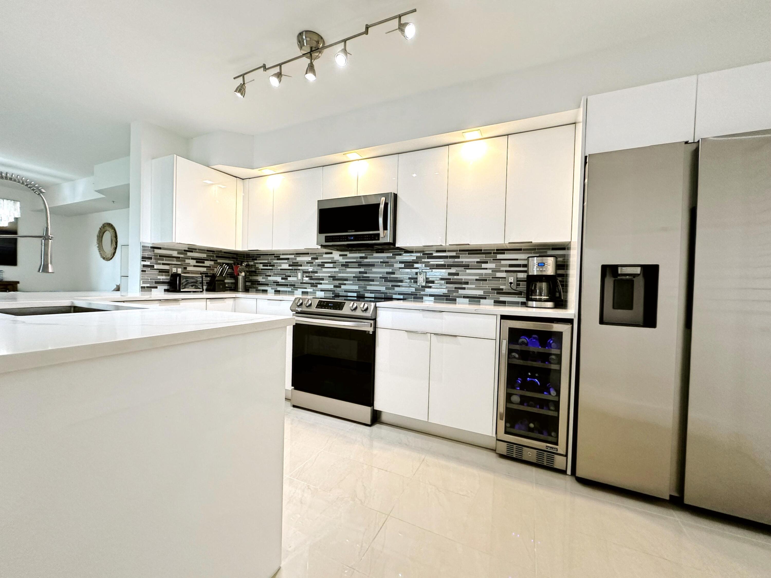 3594 South Ocean Boulevard, Unit 206 Highland Beach, FL 33487 - Photo 19 of 21 a kitchen with stainless steel appliances a refrigerator stove and sink