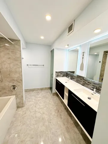 a large white kitchen with a stove a sink and a refrigerator
