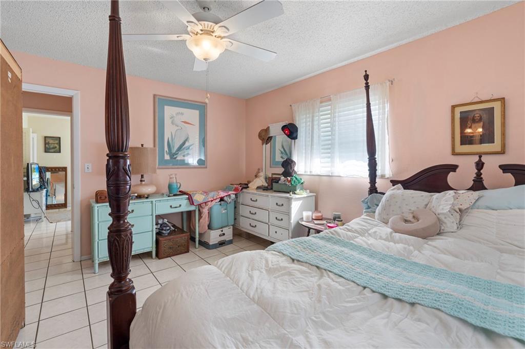 851 Barefoot Williams Road Naples, FL 34113 - Photo 16 of 35 a bedroom with a bed and a chandelier