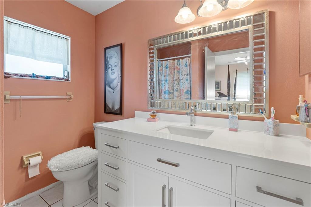 851 Barefoot Williams Road Naples, FL 34113 - Photo 17 of 35 a bathroom with a sink a toilet and mirror