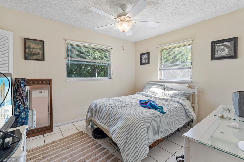 851 Barefoot Williams Road Naples, FL 34113 - Photo 19 of 35 a bedroom with a bed and a flat screen tv