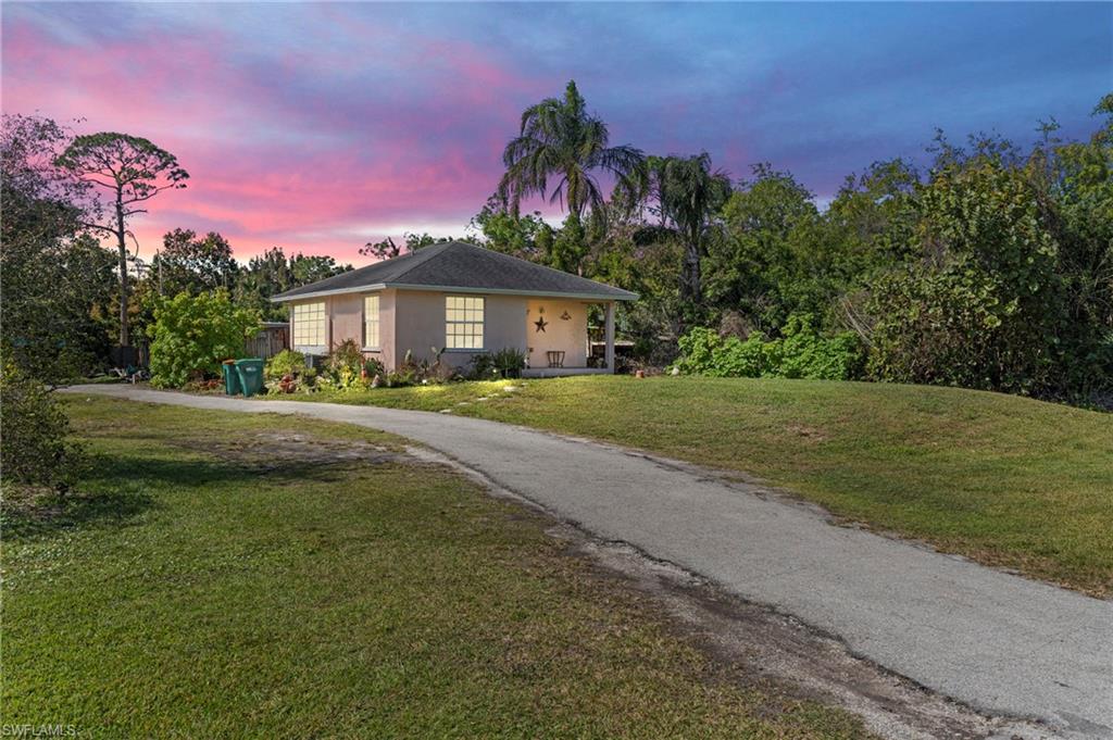 851 Barefoot Williams Road Naples, FL 34113 - Photo 3 of 35 a front view of a house with a garden and yard