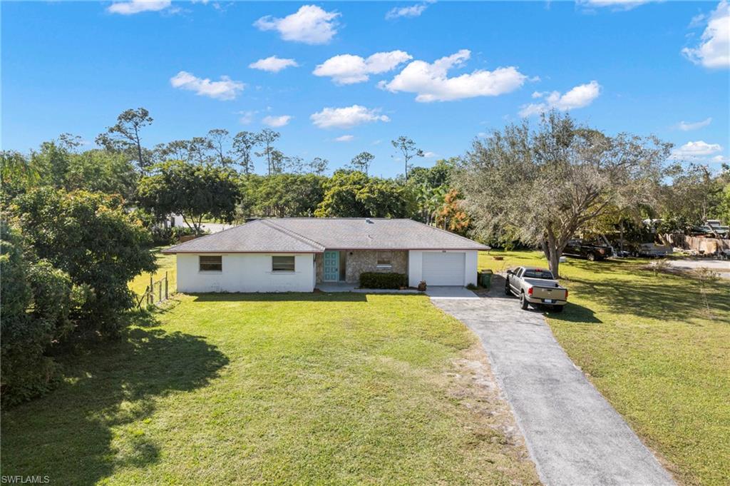 851 Barefoot Williams Road Naples, FL 34113 - Photo 7 of 35 a view of a house with a yard garage and sitting area