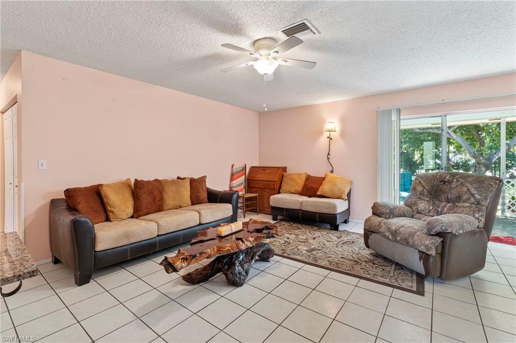 851 Barefoot Williams Road Naples, FL 34113 - Photo 9 of 35 a living room with furniture and a large window with garden view