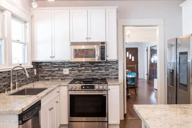 a bathroom with a granite countertop sink and a mirror