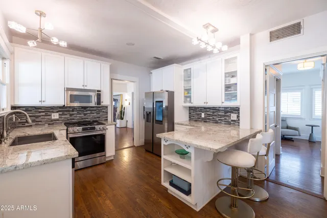 a large white bed sitting in a bathroom next to a window