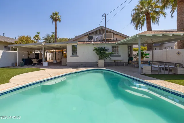 a front view of a house with swimming pool having outdoor seating