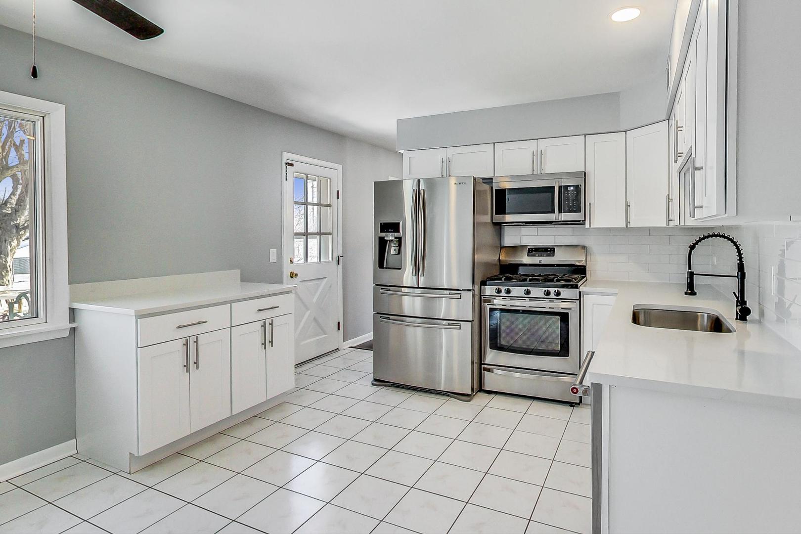 3510 East Frontage Road Rolling Meadows, IL 60008 - Photo 7 of 27 a kitchen with white cabinets and stainless steel appliances