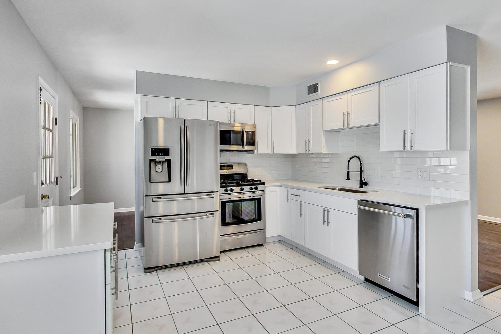 3510 East Frontage Road Rolling Meadows, IL 60008 - Photo 8 of 27 a kitchen with white cabinets stainless steel appliances and a refrigerator