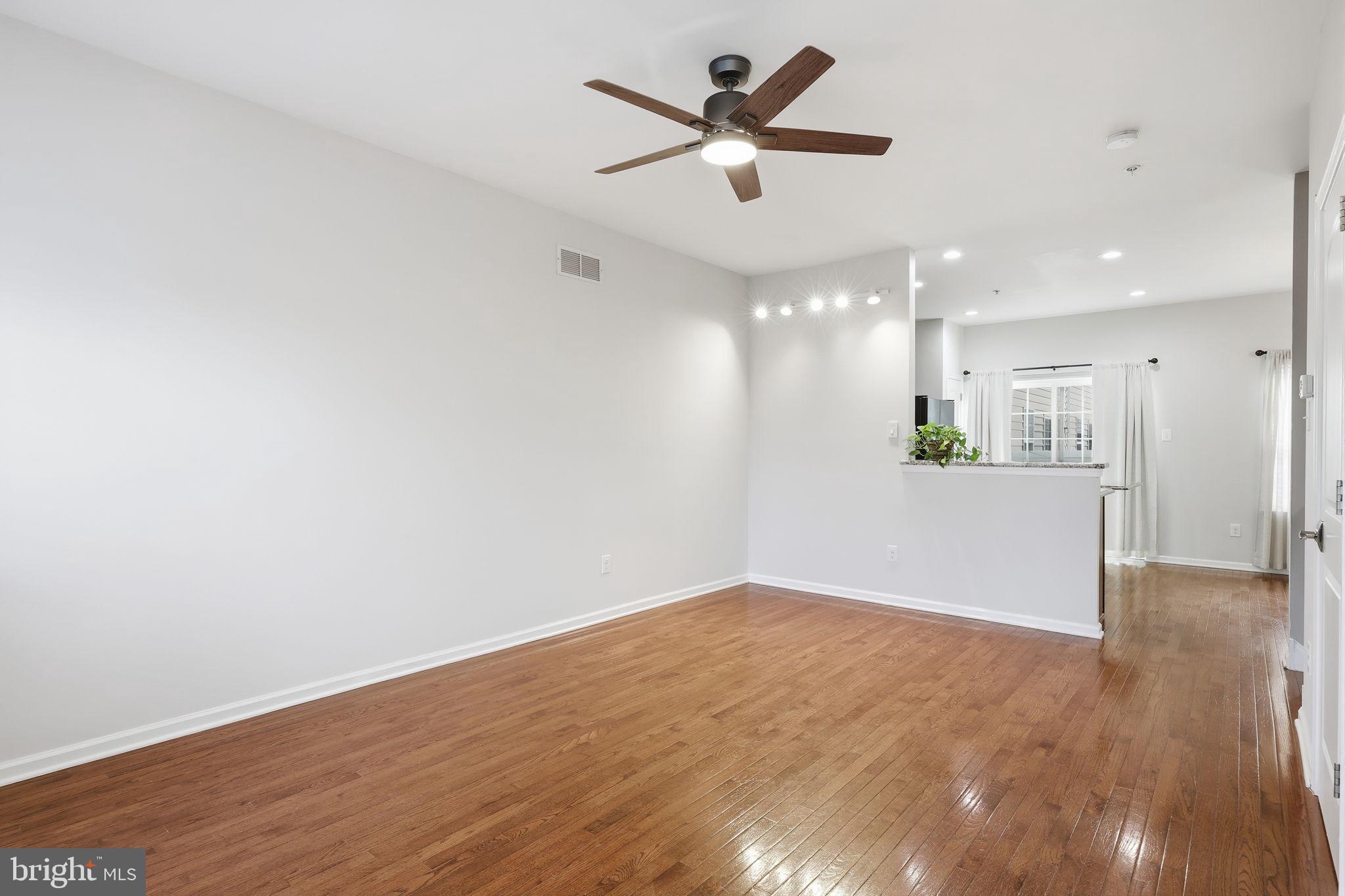 3832 William Daves Road, Unit 3 Doylestown, PA 18902 - Photo 5 of 35 a view of a big room with wooden floor a ceiling fan and kitchen view