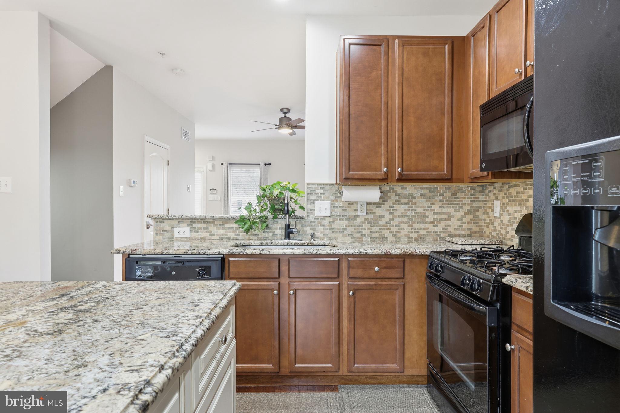 3832 William Daves Road, Unit 3 Doylestown, PA 18902 - Photo 9 of 35 a kitchen with kitchen island granite countertop a stove sink and cabinets