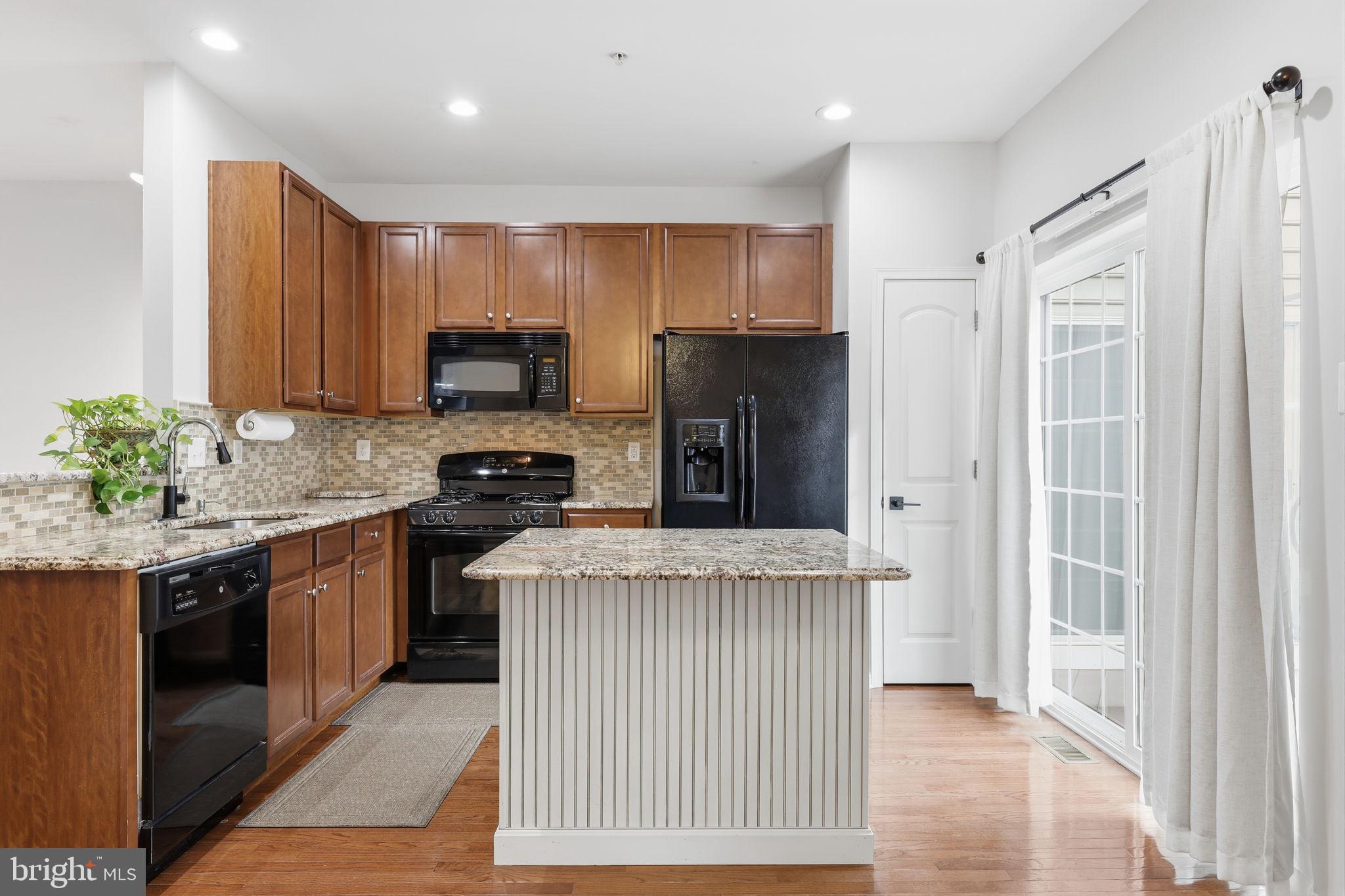 3832 William Daves Road, Unit 3 Doylestown, PA 18902 - Photo 10 of 35 a kitchen with granite countertop stainless steel appliances a stove a sink and a refrigerator