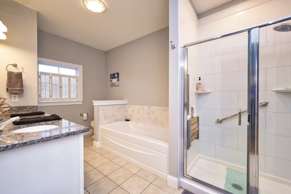 8 Hathaway Pond Circle, Unit 8 Rochester, MA 02770 - Photo 15 of 24 a bathroom with a granite countertop sink a bathtub and a shower