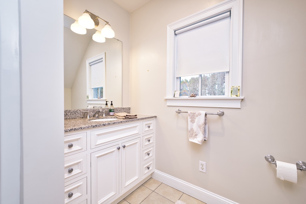 8 Hathaway Pond Circle, Unit 8 Rochester, MA 02770 - Photo 20 of 24 a bathroom with a granite countertop sink a mirror and a window