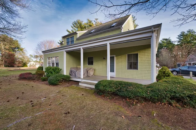 a view of a house with a small yard plants and large tree