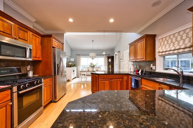 a large kitchen with stainless steel appliances granite countertop a stove a sink dishwasher a microwave oven with granite countertops and cabinets