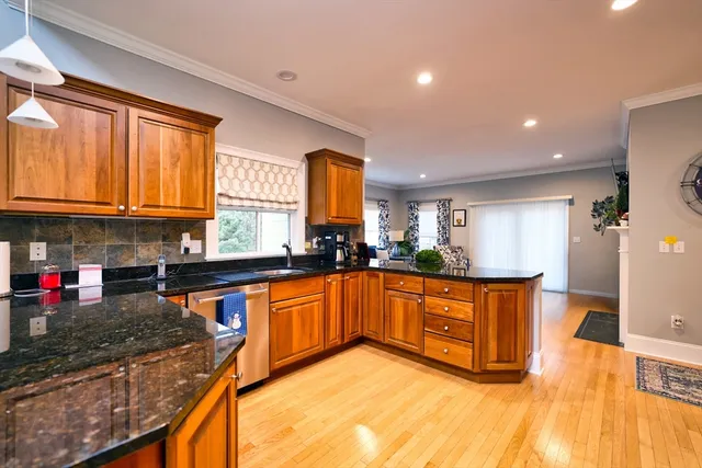 a kitchen with stainless steel appliances granite countertop a sink stove and cabinets