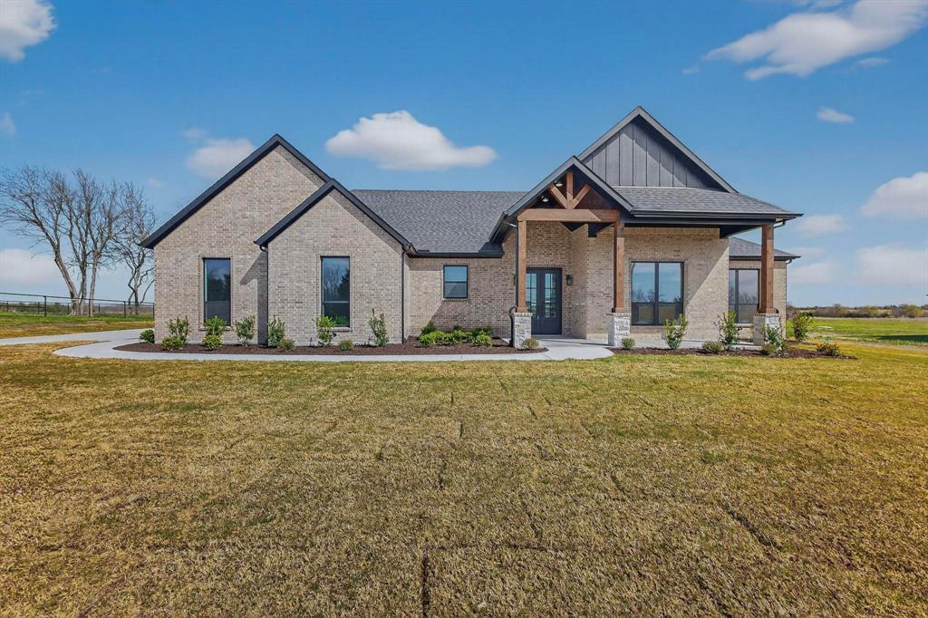 4961 County Road 1098 Celeste, TX 75423 - Photo 2 of 40 View of front of home with brick siding, a porch, a front yard, and board and batten siding