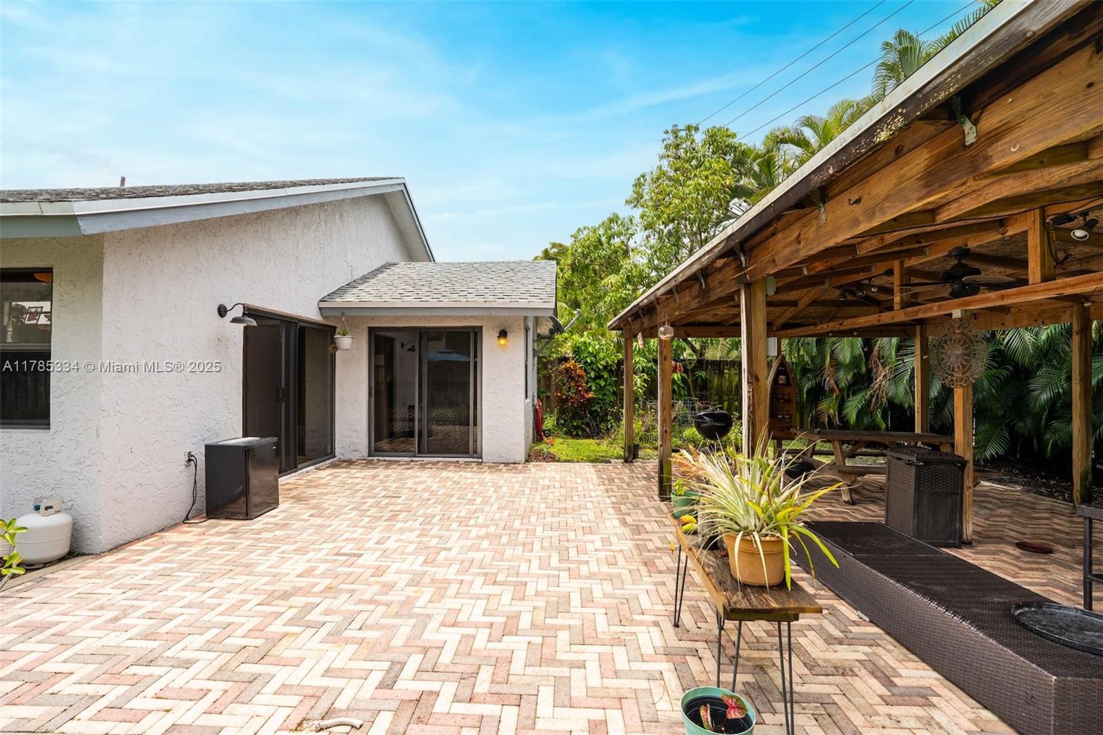 563 Lakeside Circle Sunrise, FL 33326 - Photo 27 of 36 a backyard of a house with a garden and barbeque oven