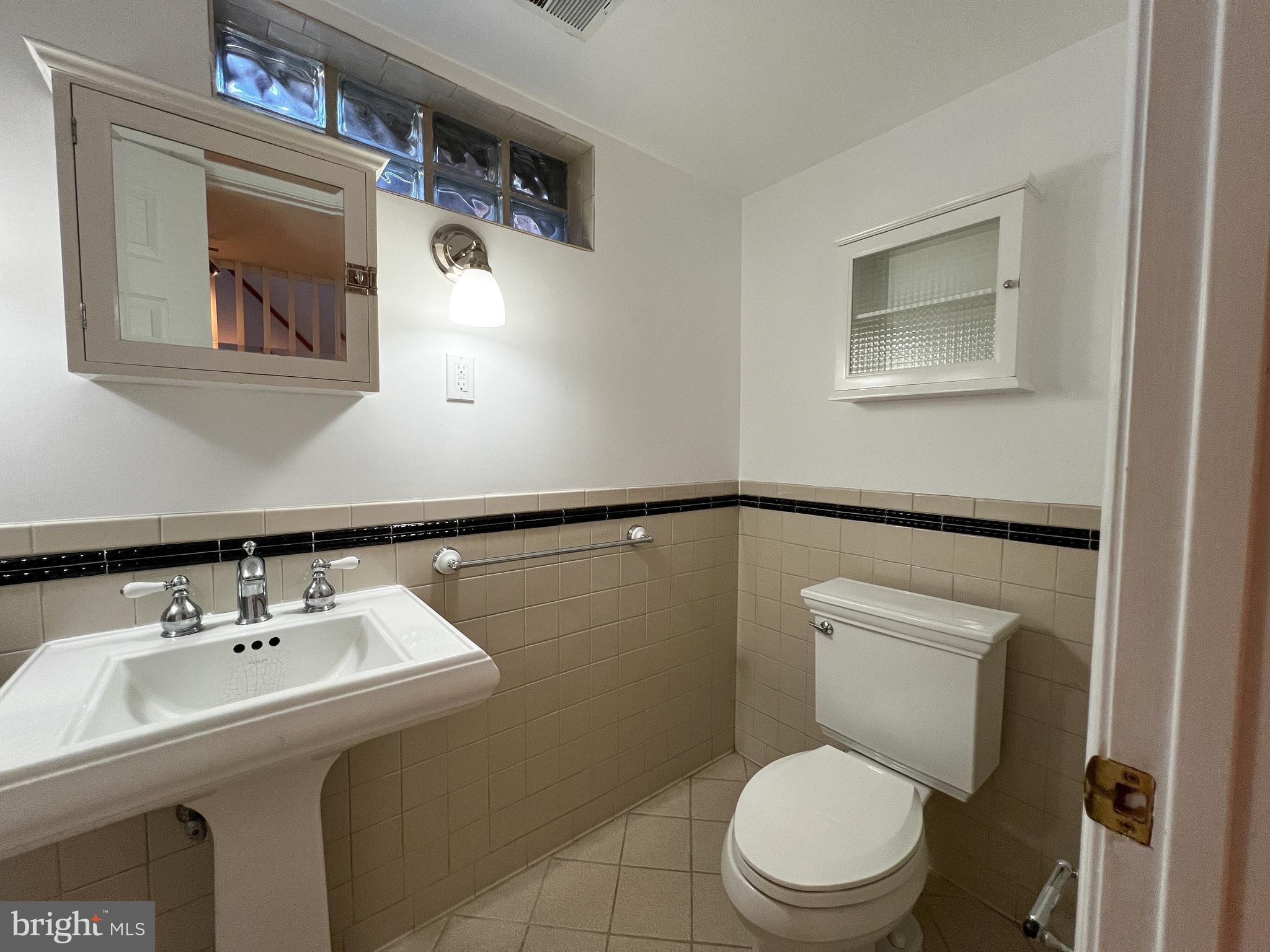 314 Hillmoor Drive Silver Spring, MD 20901 - Photo 19 of 24 a bathroom with a toilet a sink and mirror