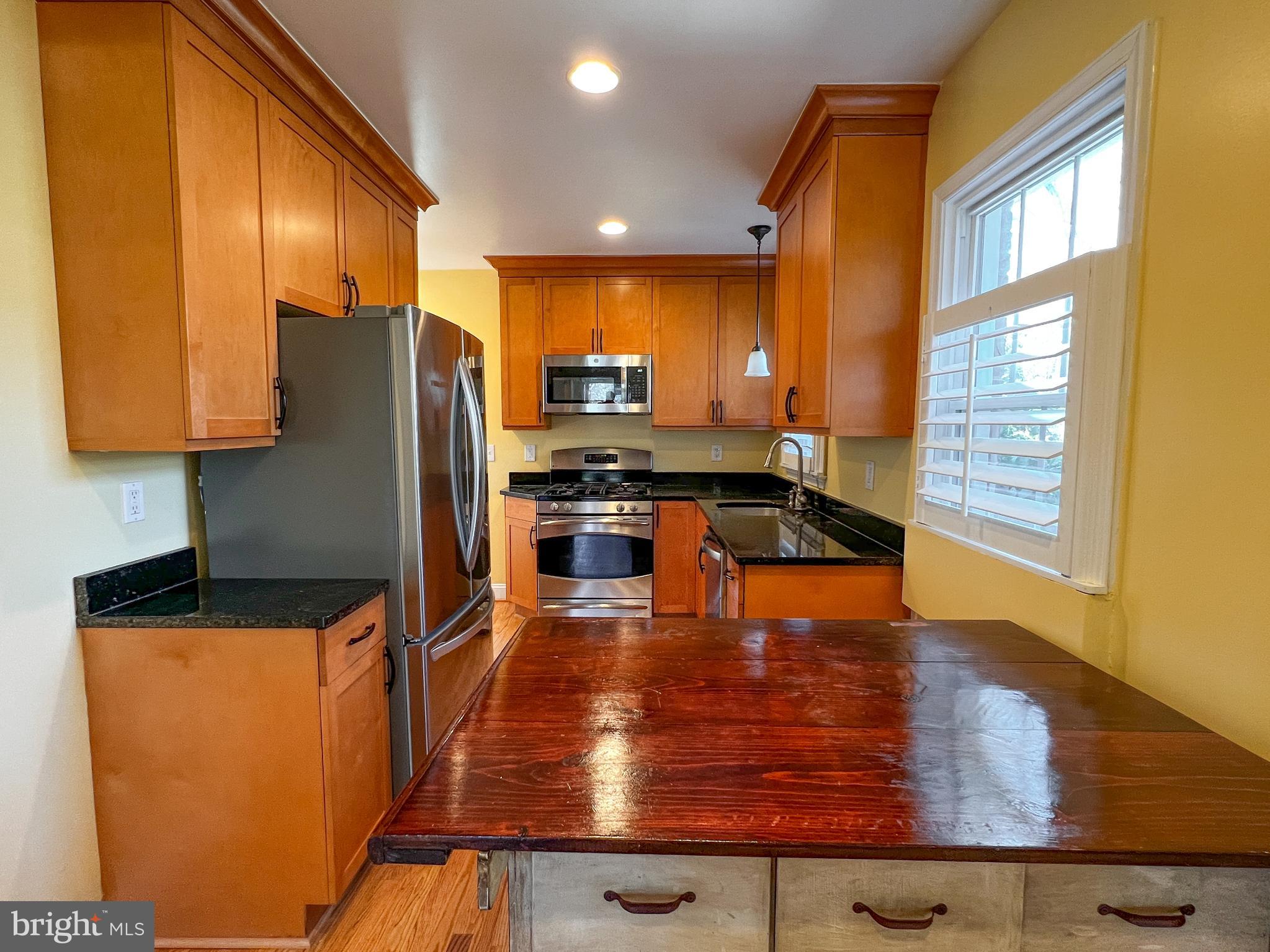 314 Hillmoor Drive Silver Spring, MD 20901 - Photo 8 of 24 a kitchen with stainless steel appliances wooden cabinets stove and a refrigerator
