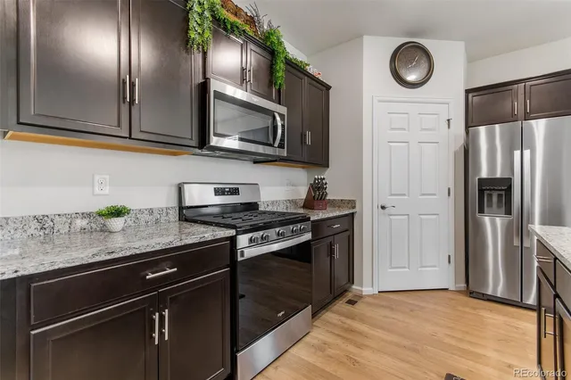 a kitchen with granite countertop stainless steel appliances and wooden cabinets