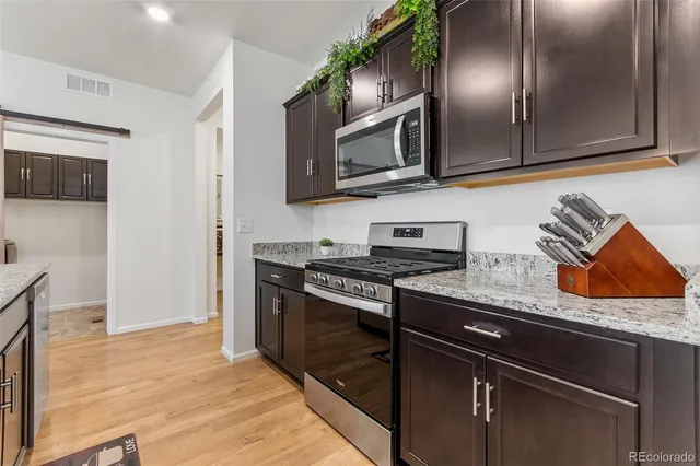 a kitchen with stainless steel appliances granite countertop a stove microwave and sink